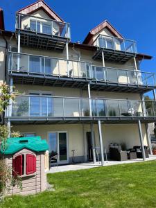 an apartment building with balconies and a yard at Villa Na Fali in Grzybowo