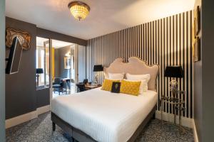 ヴァンドームにあるHotel Vendome - BW Signature Collectionのベッドルーム(白い大型ベッド、黄色い枕付)