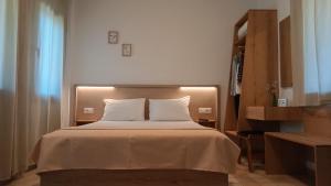 a bedroom with a large bed with white pillows at Raptis Aparthotel Sivota in Syvota