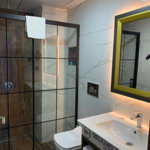 e bagno con doccia, servizi igienici e lavandino. di Grand Nergiz Otel a Antalya (Adalia)