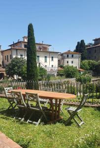 uma mesa de piquenique de madeira e cadeiras na relva em Casa di Laura in Chianti - large & charming house (host 7 people) em Moncioni