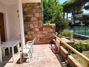 a patio with a table and chairs and a brick wall at Appartamento Eusepia, Locazione Turistica Tirrenia in Tirrenia
