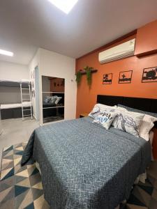 a bedroom with a bed with a blue comforter at Studio America Gardens in Rio de Janeiro