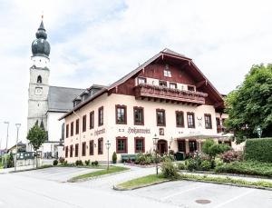 a building with a clock tower and a church at Salzburg Hotel Holznerwirt in Eugendorf