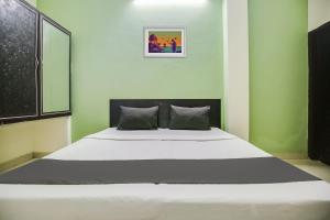 Cama grande en habitación con paredes verdes en OYO NAZ GUEST HOUSE en Jalandhar