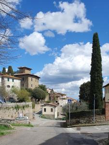uma rua numa cidade com uma árvore e edifícios em Casa di Laura in Chianti - large & charming house (host 7 people) em Moncioni