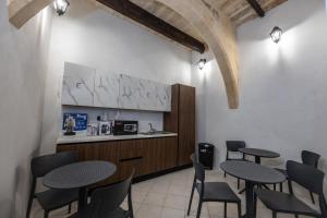 a restaurant with tables and chairs and a kitchen at Matilde Valletta Suites in Valletta