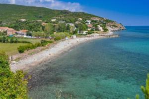 a view of a beach with people in the water at Maison corse - cap corse in Sisco