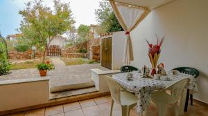 a dining room with a table and chairs on a patio at Appartamento Porta del Vento 2 in Porto San Paolo +34 photos