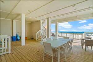 ein Esszimmer mit einem Tisch und Meerblick in der Unterkunft Beach House - Whale Rested by Panhandle Getaways in Panama City Beach