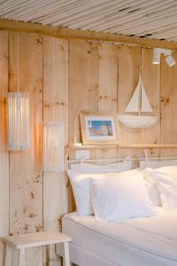 sypialnia z łóżkiem i łódką na ścianie w obiekcie Pavi apartments Vila Amalia w mieście Šilo