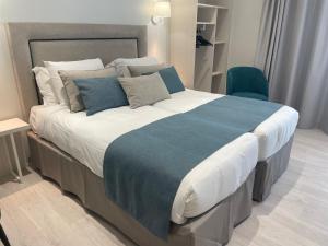 a bedroom with a large bed with a blue blanket at Kyriad Saumur Hyper Centre Hôtel Appartements et SPA soins Sothys Paris in Saumur