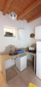una piccola cucina con lavello e microonde di Duplex Anto a San Vito lo Capo