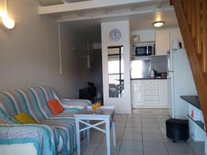 a living room with a couch and a table at Une terrasse pleine vue mer in Le Gosier