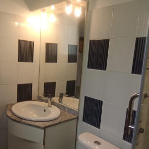 a bathroom with a sink and a toilet at Une terrasse pleine vue mer in Le Gosier