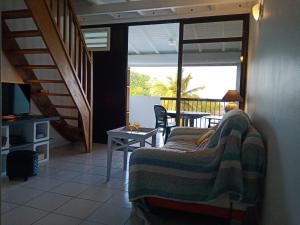 a living room with a couch and a table at Une terrasse pleine vue mer in Le Gosier