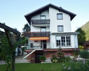 ein weißes Haus mit einem Balkon und einem Hof in der Unterkunft Ferienwohnung Piontek in Ebensee