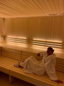 Una mujer está tumbada en una sauna en Kyriad Saumur Hyper Centre Hôtel Appartements et SPA soins Sothys Paris, en Saumur