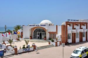 een gebouw met een moskee met een auto voor de deur bij Appart-Hôtel Tagadirt in Agadir