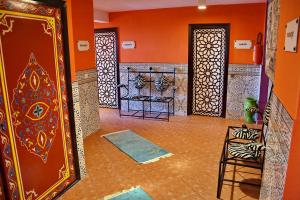 Habitación con paredes de color naranja, puerta y suelo. en Appart-Hôtel Tagadirt en Agadir