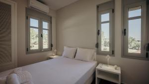 a bedroom with a white bed with two windows at Thea II Sea View Villa, Nikiti in Nikiti +124 photos