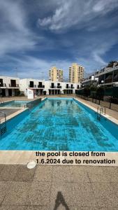 une piscine avec un panneau indiquant que la piscine est fermée de dans l'établissement Las Americas Bungamar apartment, à Playa de las Americas