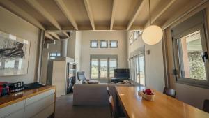 a kitchen and dining room with a table and a living room at Thea II Sea View Villa, Nikiti in Nikiti