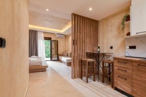 a kitchen with a bar and a living room at Odyssey Accommodation - Apartments in Pefkochori