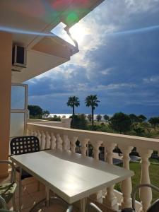 a table on a balcony with a view of the ocean at Aktaion apartments in Artemísion