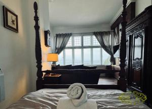 Un dormitorio con una cama con una toalla. en Royal Marine Hotel Dunoon en Kirn