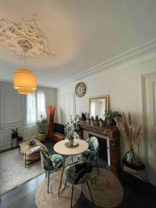 una sala de estar con una mesa y una chimenea en Superbe T2 de caractère au centre classé 3 étoiles, en Troyes