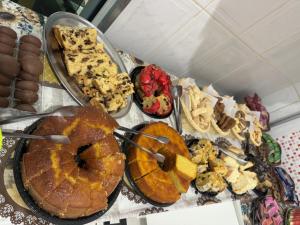 una mesa con diferentes tipos de comida y postres en Pousada Rabake, en Aparecida