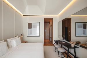 a bedroom with a white bed and a desk at The Lince Santa Clara in Vila do Conde