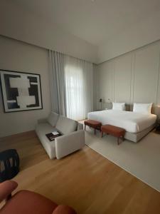 a hotel room with a large bed and a couch at The Lince Santa Clara in Vila do Conde