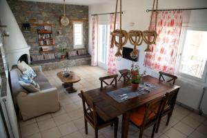 a living room with a wooden table and chairs at Kapari Home Syros in Vári