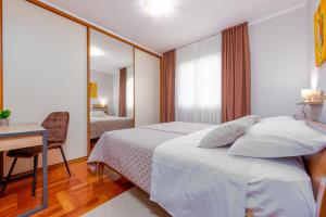 a hotel room with a bed and a desk at Apartment Matea with terrace in Zadar