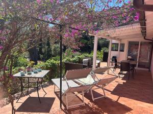 un patio con tavolo, sedie e fiori viola di Suosogno sul mare 200metri dalla spiaggia a Capoliveri