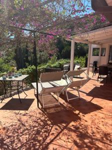 un patio con tavolo, sedie e fiori rosa di Suosogno sul mare 200metri dalla spiaggia a Capoliveri