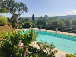 a swimming pool with trees and a mountain in the background at Les collines de St Paul in Saint Paul de Vence
