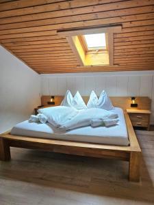 een bed met witte lakens en kussens erop bij Haus Marinus in Jerzens