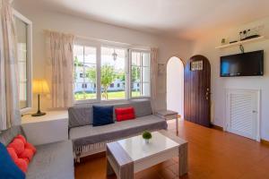 una sala de estar con un sofá y una mesa en Acuario, en Son Bou