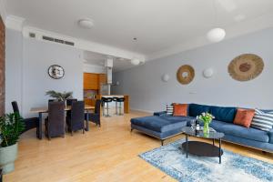a living room with a blue couch and a table at AS HOME Apartamenty Rynek 50 R503 Amazing View in Wrocław