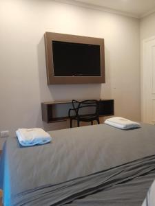 um quarto com uma cama e uma televisão de ecrã plano em Hotel Azul Junin em Junín