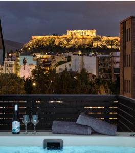 a bath tub with wine glasses and a view ofhens at Acropolis view Penthouse46 Jacuzzi Quality living in Athens