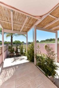 an outdoor patio with a wooden pergola at Casa Vacanze - Costa Salentina in San Foca