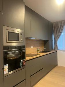a kitchen with a stove and a microwave at Luxury Sunny Apartments near City Center Suceava in Suceava +69 photos