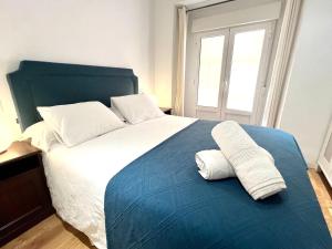 1 dormitorio con 1 cama grande y 2 toallas. en Exclusive Apartment in Historic Center, en Madrid