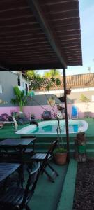 瓜魯雅的住宿－Suíte Luxo Refúgio das Ostras，一个带椅子和桌子的游泳池以及一把遮阳伞