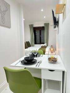 a white table with a plate of food and wine glasses at Tower Bridge Studios in London +34 photos