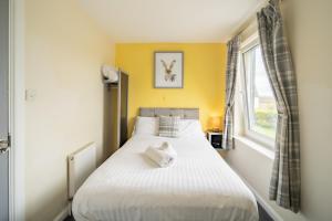sypialnia z dużym białym łóżkiem i oknem w obiekcie The Well Inn w mieście Shepton Mallet